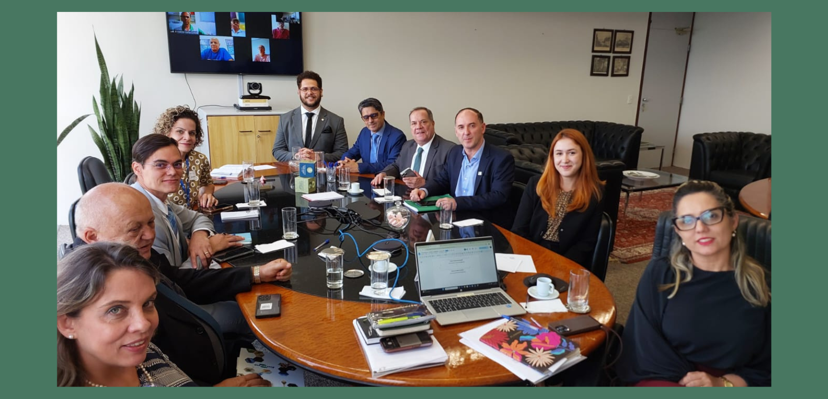 foto da mesa com os integrantes e da tv ao fundo.